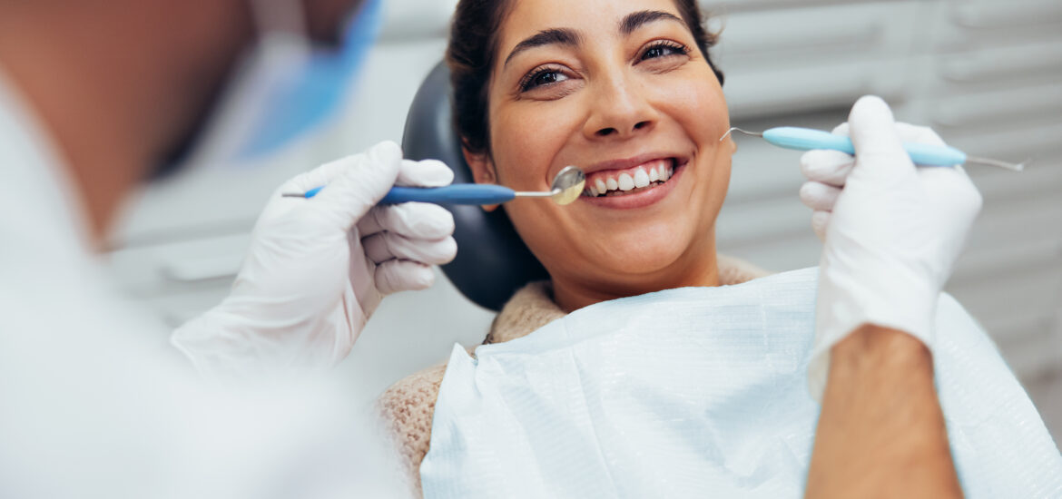 dentist checking a woman's tooth infection, need for root canal therapy