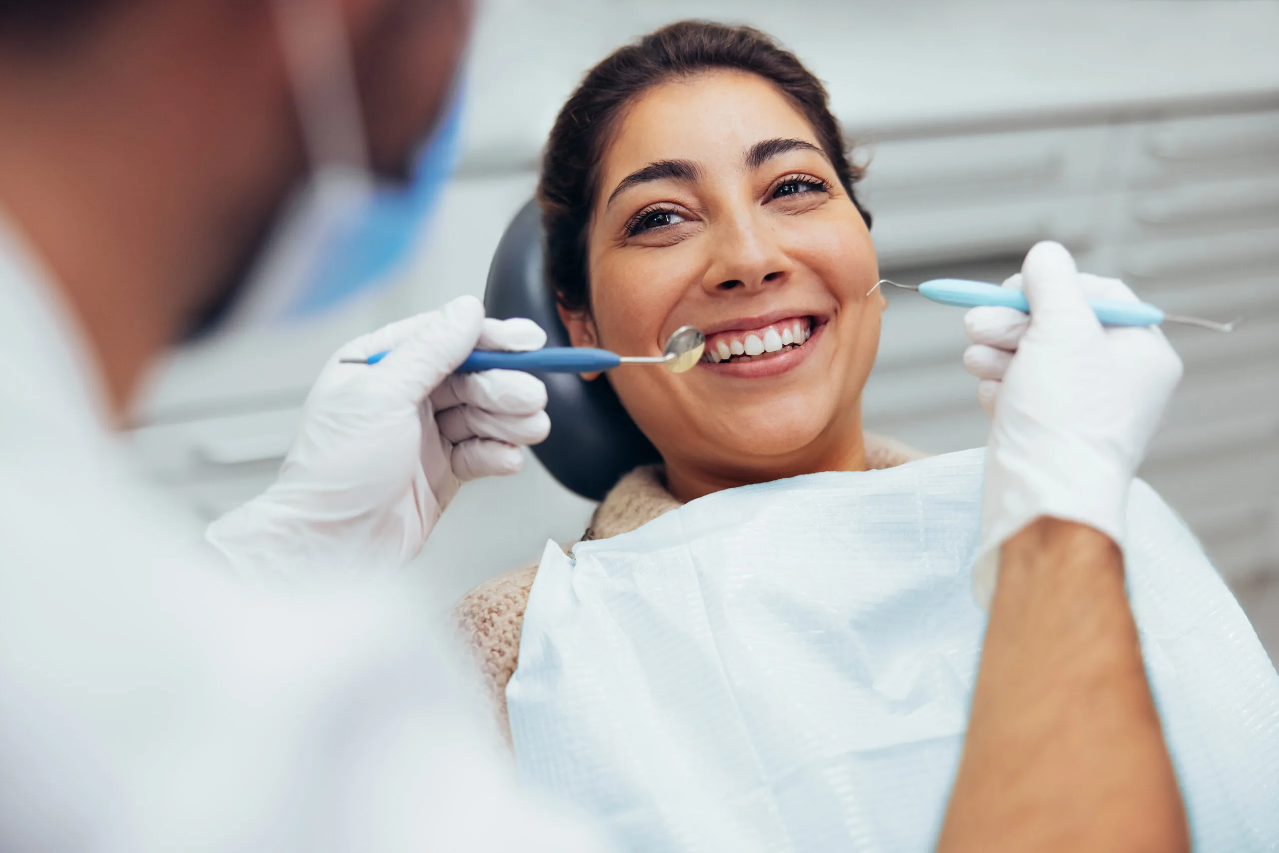 dentist checking a woman's tooth infection, need for root canal therapy