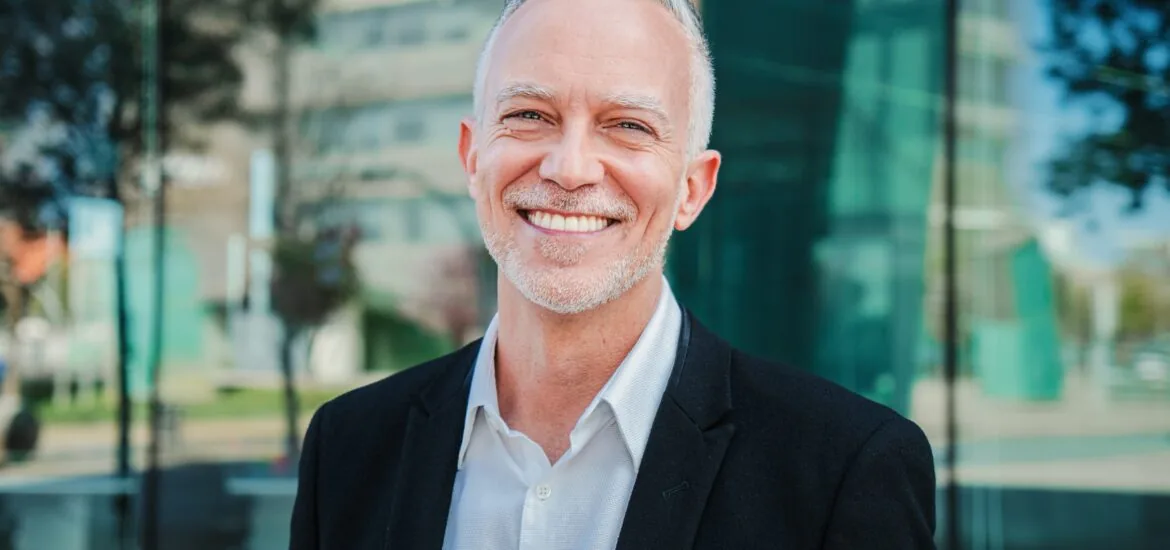 Close up portrait of mature adult business man with gray hair and suit and perfect white smile