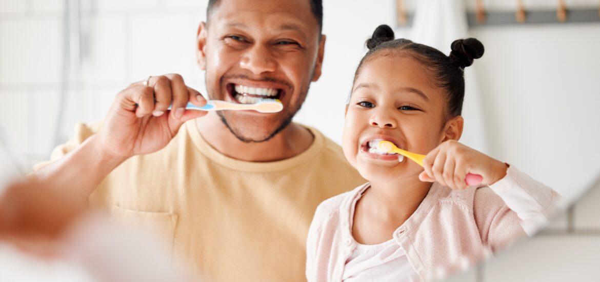 father and daughter brushing their teeth and practicing proactive care in Staten Island