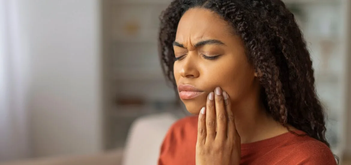 young woman suffering from tooth pain in Staten Island
