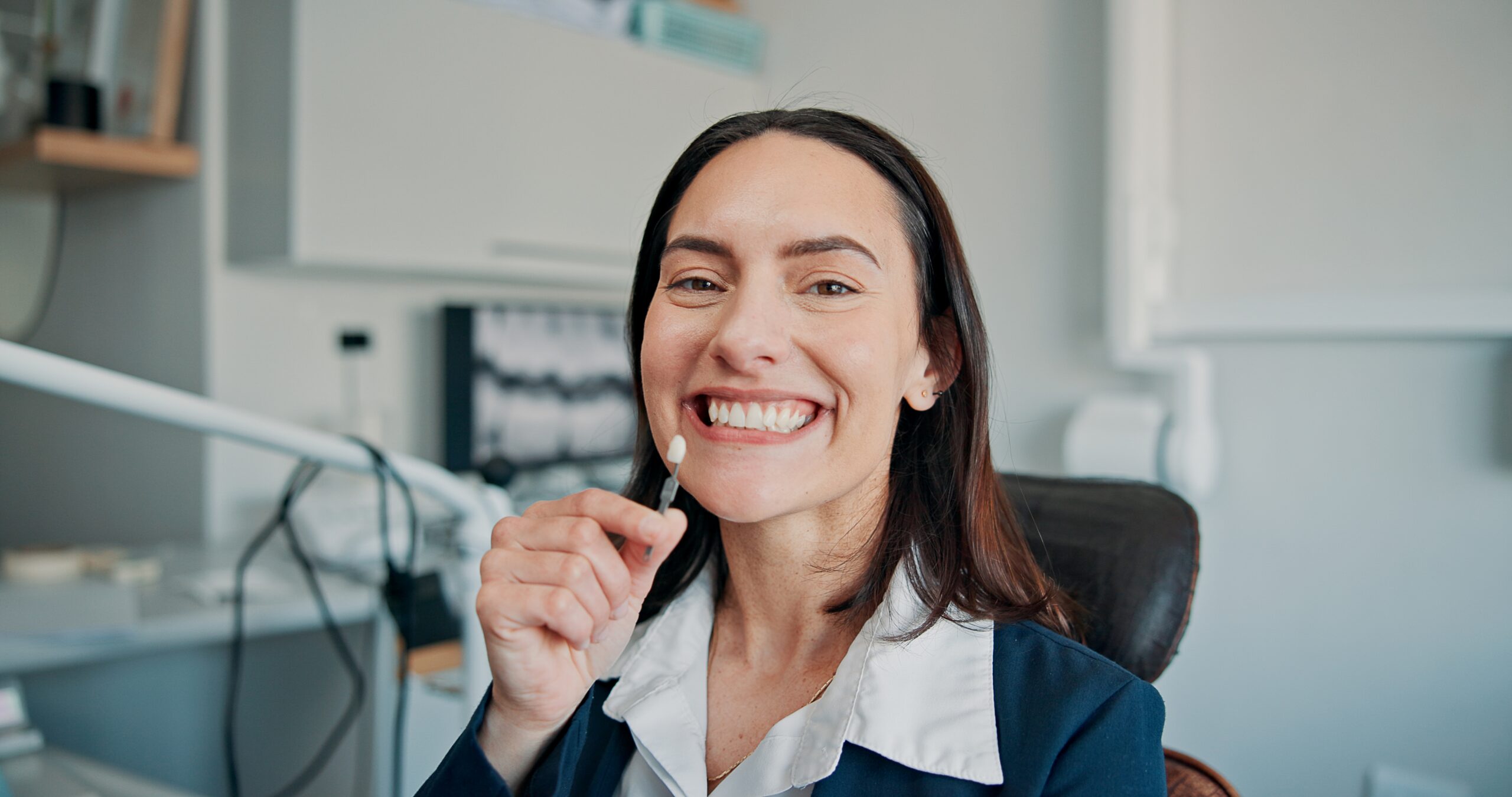 smiling woman sitting in a dental chair, dental implants